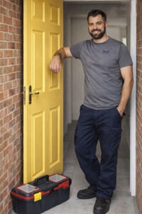 Neal standing by a door